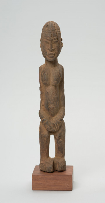 rzeźba - Ujęcie z przodu; Figura - postać przodka w pozycji stojącej. Głowa podłużna, zaokrąglona. Rysy 