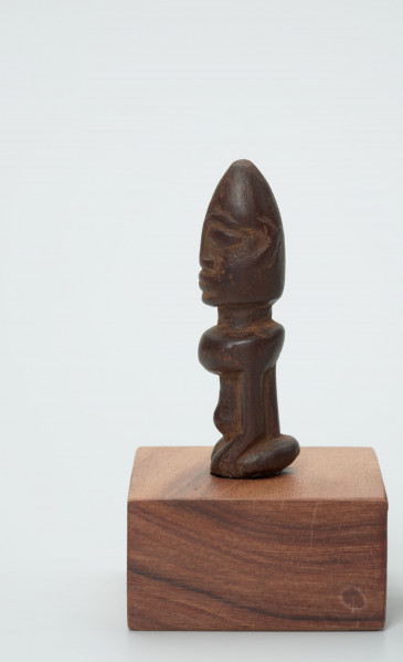 rzeźba - Ujęcie z drugiego boku; Figura - postać przodka przedstawiająca przodka w pozycji siedzącej (klęczącej?) na ugiętych w kolanach nogach. Głowa duża, ok. ? powierzchni figurki. Wyraźnie zaznaczone rysy 
