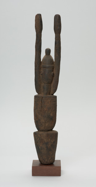 rzeźba - Ujęcie z tyłu. Figurka przedstawia Hogona – kapłana kultu Lebe. Widoczna broda, wyprostowane ręce uniesione do góry.