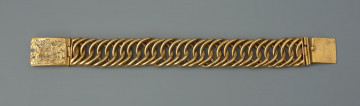 Bransoleta z sarkofagu księcia Franciszka I (1577 - 1620) - Ujęcie z przodu. Bransoleta wykonana ze skręconych, przenikających się ogniw, w tzw. splocie pancerzowym. Na prostokątnych zapinkach dziewięciopolowy herb Księstwa Pomorskiego trzymany przez dzikich mężów, pierwotnie emaliowany. Na spodzie klamry ryta inskrypcja, pierwotnie emaliowana: V.G.G. / CLARA / G.Z.B.V.L. / H.Z.S.Pō /15.96. Na bocznych ściankach wykonana w tej samej technice inskrypcja: V.G.G. FRANTZ / H.Z.S.Pom.