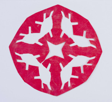 Wycinanka różowa w formie wieloboku z gwiazdą czteroramienną ażurowaną w centrum. Dookoła poczwórny motyw grzybków.
