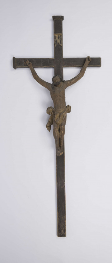Rzeźba w drewnie przedstawiająca Chrystusa Ukrzyżowanego na krzyżu. Polichromowany. Włosy i broda czarne, pozostałe części oliwkowe. U góry na krzyżu tabliczka z napisem „INRI”.