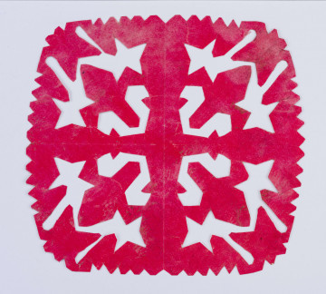 Wycinanka różowa w formie kwadratu, brzeg ząbkowany, w środku motyw krzyża o kolumnowatych ramionach. Otok z 