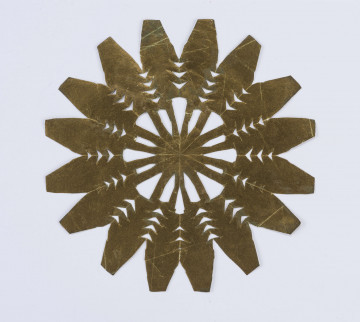 Wycinanka ze złotego glansowanego papieru, w formie gwiazdy 16ramiennej o ramionach w kształcie ściętych stożków u dołu ząbkowanych. Środek ażurowany w trójkąty.
