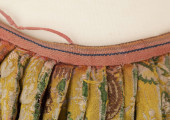 E/880/ML - Spódnica wykonana z brokatu, różnobarwna w kwiaty. Przewaga koloru złotego. Posiada lnianą podszewkę. Na przodzie wstawione lniane płótno w pasy. Noszona przez zamężne kobiety, bogate mieszczki tarnogrodzkie.