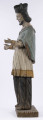 E/8422/ML - Rzeźba drewniana, pełna, polichromowana, przedstawiająca św. Jana Nepomucena. Zakomponowana frontalnie, z rękoma zgiętymi w łokciu i lekko rozłożonymi. Twarz owalna, pomalowana białą farbą. Małą broda i krótkie czarne wąsy. Nos krótki, prosty. Oczy owalne podkreślone czarnym konturem. Brwi łukowate, wąskie, czarne. Włosy czarne, ułożone w pukle. Na głowie czarny biret. Długa czarna sutanna, biała komża ozdobiona u dołu złotą koronką. Na piersiach krzyż, zawieszony na łańcuchu. Na komżę narzucona jasnoniebieska peleryna. Stopy lekko rozstawione. Obuty w sandały o jednym pasku. 

Konserwacja: 1990 r.
