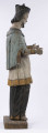 E/8422/ML - Rzeźba drewniana, pełna, polichromowana, przedstawiająca św. Jana Nepomucena. Zakomponowana frontalnie, z rękoma zgiętymi w łokciu i lekko rozłożonymi. Twarz owalna, pomalowana białą farbą. Małą broda i krótkie czarne wąsy. Nos krótki, prosty. Oczy owalne podkreślone czarnym konturem. Brwi łukowate, wąskie, czarne. Włosy czarne, ułożone w pukle. Na głowie czarny biret. Długa czarna sutanna, biała komża ozdobiona u dołu złotą koronką. Na piersiach krzyż, zawieszony na łańcuchu. Na komżę narzucona jasnoniebieska peleryna. Stopy lekko rozstawione. Obuty w sandały o jednym pasku. 

Konserwacja: 1990 r.