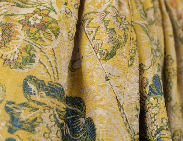 E/880/ML - Spódnica wykonana z brokatu, różnobarwna w kwiaty. Przewaga koloru złotego. Posiada lnianą podszewkę. Na przodzie wstawione lniane płótno w pasy. Noszona przez zamężne kobiety, bogate mieszczki tarnogrodzkie.
