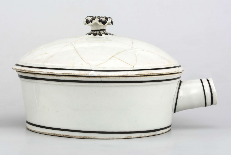 Naczynie stożkowate z uchwytem w postaci szerokiej rurki (służącym do zamocowania drewnianej rączki), pokrywa kopulasta z uchwytem w kształcie rozkwitłej korony kwiatowej. Krawędzie obwiedzione czarnymi paskami, czernią podkreślony modelunek uchwytu. Spód nieszkliwiony.
 