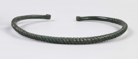 1395/A/ML/1 - Naszyjnik brązowy wykonany z brązowego pręta lanego, pokryta zieloną patyną. Całość spiralnie skręcona; końcówki rozklepane (płasko) i wywynięte na zewnątrz; końcówki naszyjnika gładkie nie skręcane 