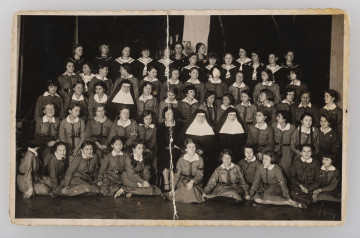 ML/MART/948 - Fotografia grupowa harcerek z ss. Urszulankami, w ostatnim rzędzie 4 od lewej Wanda Wojtasik. W 5 rzędach stoją i siedzą harcerki, pośrodku nich siedzą 3 zakonnice i nauczycielka. Na odwrocie podpisy harcerek.