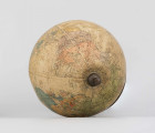 Mały polityczny globus Ziemi z polską nomenklaturą w skali 1:100 mln. Litografia kolorowa; 12 segmentów i 2 koła. Globus zamontowany na ramieniu drucianym, model 