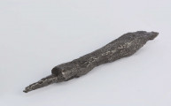 Grot żelazny, w przekroju czworoboczny, ostro zakończony, w części środkowej nieco zwężony; trzpień osadzony centralnie w przekroju poprzecznym czworoboku