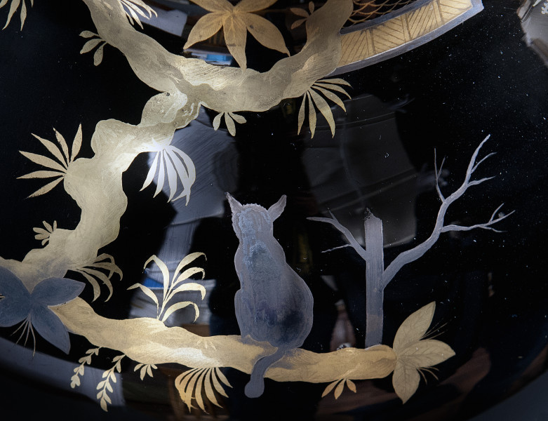 detal - dekoracja chinoiserie. Pole ograniczone od góry, dołu i lewej złoconymi konarami drzewa, zawierające w centrum srebrnoniebieskiego kota siedzącego na konarze oraz srebrnoniebieskie drzewo po prawej. Z konarów wyrastają gałązki i listki, na przecięciu konarów niebieski, wysrebrzony kwiat. 