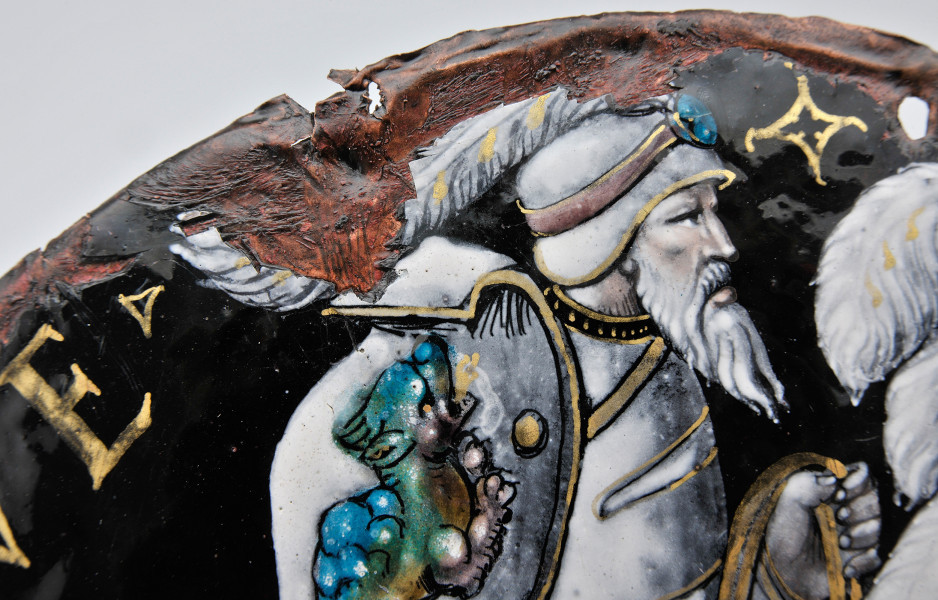 awers – fragment górny, ujęcie powyżej pasa brodatego mężczyzny w hełmie zdobionym piórem i niebieskim kamieniem, duże uszkodzenia emalii na krawędziach.