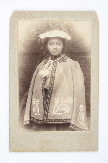 Fotografia Henryki Rodkiewiczówny w białym berecie na głowie i w kożuszku góralskim wyszywanym w szarotki.