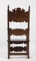 Fotel drewniany z  siedziskiem i oparciem drewnianym bez wyściełania, na prostych nogach z czterema łączynami. Nogi tylne przechodzą w ramiaki boczne oparcia. Oparcie prostokątne, lekko odchylone do tyłu. Zaplecek ażurowy złożony z dwóch bogato rzeźbionych desek:
- górna w ornamenty wolutowe wokół środkowago owalnego medalionu, z ozdobnie wyciątą dolną krawędzią i wyodrębnionym zwieńczeniem w kształcie przełamanego tympanonu z centralnym kartuszem
- dolna - węższa, powtarza główny motyw zdobienia.
Poręcze graniaste zakończone małymi wolutkami, u nasady rzeźbione liście akantu, podpórki w środkowej części rzeźbione. Płyta siedzenia prostokątna z rzeźbionym fartuchem z przodu. Łączyny boczne i tylna - graniaste, łączyna przednia w postaci deski o ozdobnym wykroju, rzeźbionej w ornamenty wolutowe.