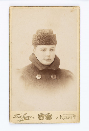 Fotografia Toli Certowiczówny, twarz en face, na głowie barankowy toczek, ubrana w palto z kołnierzem i z dwurzędowym zapięciem.