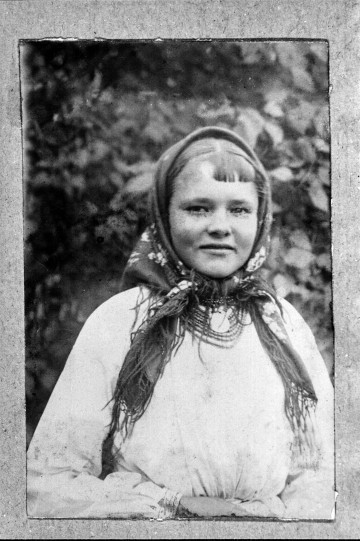 Fotografia czarno-biała przedstawia młodą dziewczynę ubraną w strój biłgorajski.