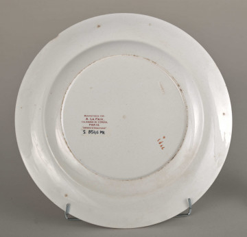 Talerz płytki, zdobiony motywem roślinnym, kwiatowym i geometrycznym w kolorze zielonym, czerwonym, niebieskim i złotym. Spód