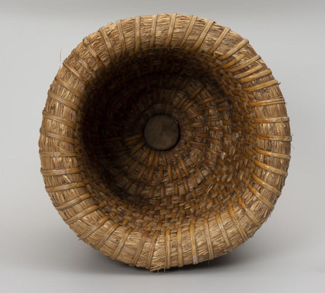 Kószka (ul kopulasty) - ujęcie z góry; Duża kószka wykonana techniką spiralną z ciasno splecionych warkoczy słomianych. Okrągły otwór pośrodku. Otwór zatkany drewnianym klockiem o kształcie walca.