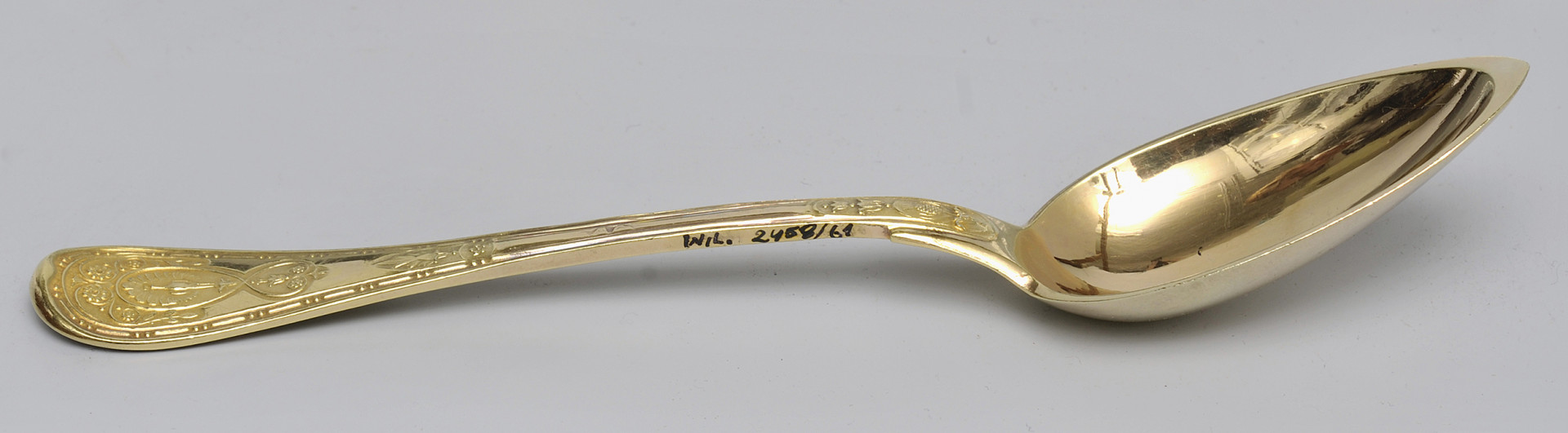 ujęcie 3/4 - widoczna wewnętrzna strona czerpaka. Ujęcie z nabierakiem po prawej stronie i napisem inwentarzowym na bocznej krawędzi rączki.