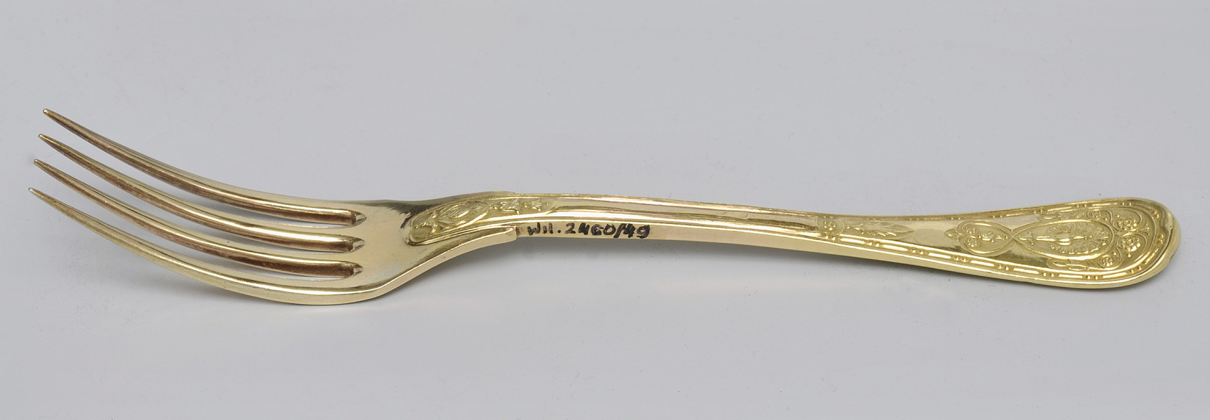 ujęcie 3/4 – od strony awersu. Zębiska po lewej stronie; w górnej części bocznej krawędzi rączki napis inwentarzowy.