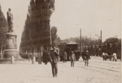 zbliżenie na prawy fragment zdjęcia. Po lewej pomnik Bobrińskiego, w centrum, na pierwszym planie mężczyzna w czapce z daszkiem kierujący się w stronę obiektywu, dalej przystanek i pasażerowie wysiadający z wagonu tramwaju oraz chłopi przy wozie konnym