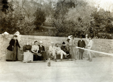 Na zdjęciu znajduje się grupa osób na korcie tenisowym.