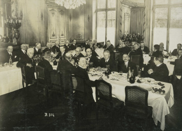 Na zdjęciu znajduje sie grupa mężczyzn siedzących za stołem.
