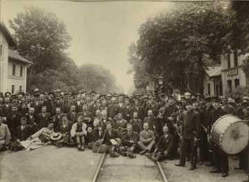 Fotografia grupowa przy stacji kolejowej.