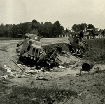 Na zdjęciu znajduje się wrak samochodu pancernego, z licznymi częśćiami, porozrzucanymi na poboczu drogi