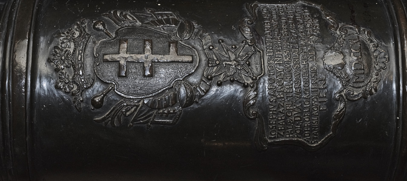 Na zdjeciu znajduje się fragment Lufy armatniej, napis i herb Potockich.