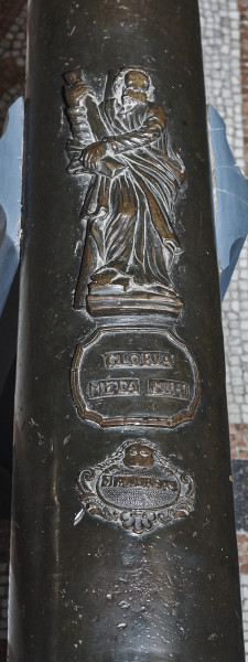 Na zdjęciu znajduje się fragment lufy armatniej gdzie umieszczono płaskorzeźbe św. Andrzeja a poniżej plakietę z napisem GLORIA META MIEHI