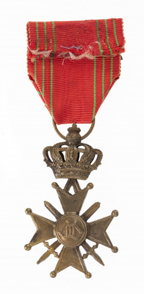 Odznaką Croix de Guerre jest krzyż równoramienny o wym. 3,8 x 3,8 cm. Ramiona krzyża matowe z obramowaniem, rozszerzają się od 0,5 do 1,7 cm, zakończone kulkami, z trójkątnym wcięciem. Pomiędzy ramionami skrzyżowane dwa miecze długości 3,5 cm. Medalion krzyża mocno uwypuklony z herbem Belgii (lew wspięty na tylych nogach). Przy górnym ramieniu przywieszka zawiasowo połączona z zamkniętą koroną ośmioramienną, zwieńczoną kulą z krzyżem. Korona w przekroju poziomym eliptyczna. W kulistym zwieńczeniu korony otwór z przełożonym kółkiem. Wstążka odznaczenia szerokości 3,8 cm czerwona z sześcioma zielonymi paskami i nałożoną  poziomo gałązką palmową.