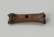 hetka - Ujęcie z przodu; Hetka o zachowanej formie krótkiej kości śródstopia zwierzęcia z otworem przelotowym w środkowej części.