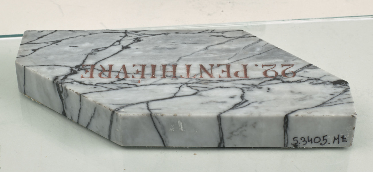 Kamień pamiątkowy z białego marmuru, ma napis: 