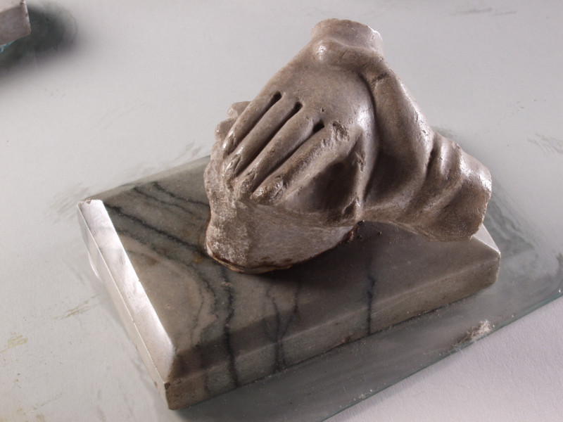 Model dwóch splecionych dłoni, na prostokątnej podstawie, szary marmur