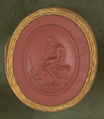 czerwona owalna gemma w grubym złotym obramowaniu; nagi umięśniony mężczyzna siedzi na skórze lwa rozłożonej na skale; w prawej ręce trzyma miecz, na którym się opiera; obok prawej stopy mężczyzny stoi oparta maczuga