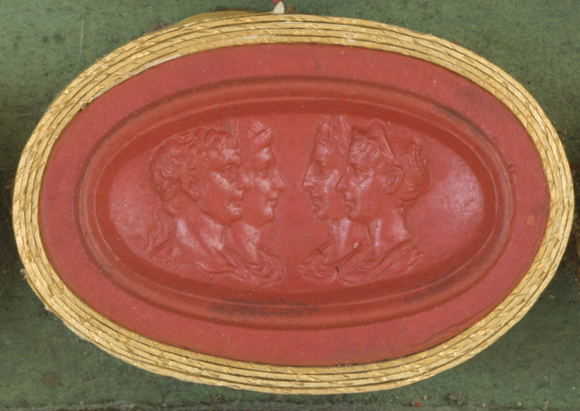 czerwona owalna gemma w grubym złotym obramowaniu; dwie pary postaci zwróconych do siebie twarzami, mężczyzna ma krótkie włosy, kobiety włosy spięte
