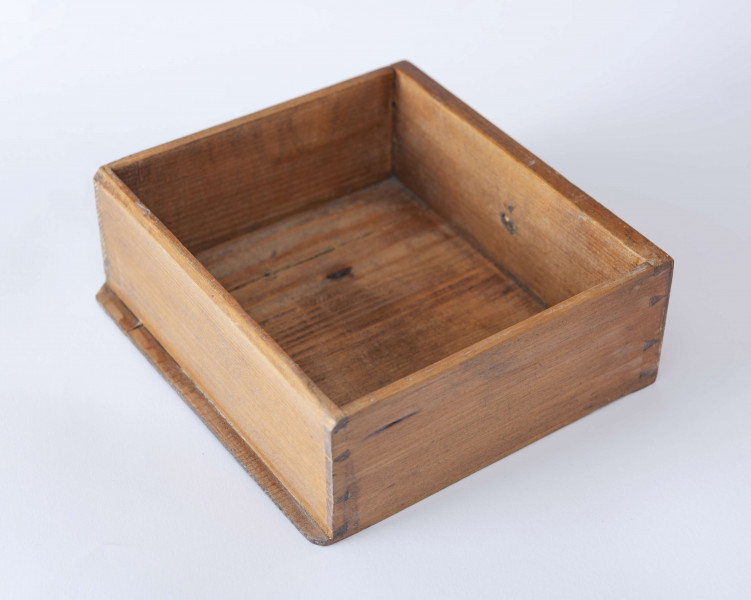 Biurko przyścienne na sześciu nóżkach graniastych zbieżnych. W części dolnej prostokątny prześwit zamknięty tylną ścianą. Po jego bokach po dwie szuflady, powyżej jeszcze trzy. Część górna ćwierćcylindryczna zamykana żaluzją chowaną pod górna płytą powyżej pięciu szufladek, boki zdobione plastycznym ornamentem cekinowym. Lico pokryte fornirem z intarsją ramkową i wzorem arkadkowym. Blat wyłożony skórą cielęcą. Uchwyty szuflad zewnętrznych i żaluzji to nałożone okucia okrągłe z tarczą, szufladki w części górnej mają uchwyty okrągłe z gładką główką.  