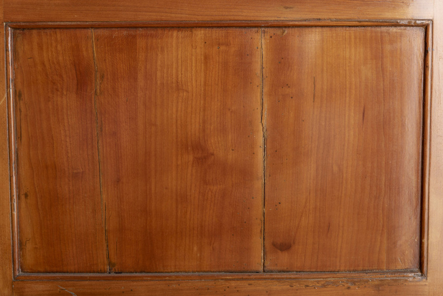 Biurko przyścienne na sześciu nóżkach graniastych zbieżnych. W części dolnej prostokątny prześwit zamknięty tylną ścianą. Po jego bokach po dwie szuflady, powyżej jeszcze trzy. Część górna ćwierćcylindryczna zamykana żaluzją chowaną pod górna płytą powyżej pięciu szufladek, boki zdobione plastycznym ornamentem cekinowym. Lico pokryte fornirem z intarsją ramkową i wzorem arkadkowym. Blat wyłożony skórą cielęcą. Uchwyty szuflad zewnętrznych i żaluzji to nałożone okucia okrągłe z tarczą, szufladki w części górnej mają uchwyty okrągłe z gładką główką.  