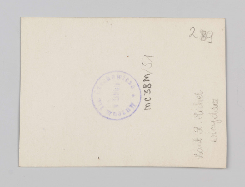 MC/M/38/51/ML - Fotografia w pozycji pionowej. Widok na wnętrze wirydarza od strony północno zachodniej. Przestrzeń otoczona arkadami o wsmukłych kolumnach i łuku ostrym. Po prawej zakończony półkoliście duży maswerk lewego transeptu. Po lewej widoczna absyda z konstrukcją przyporową.
Na odwrocie po środku niebieska okrągła pieczątka: 