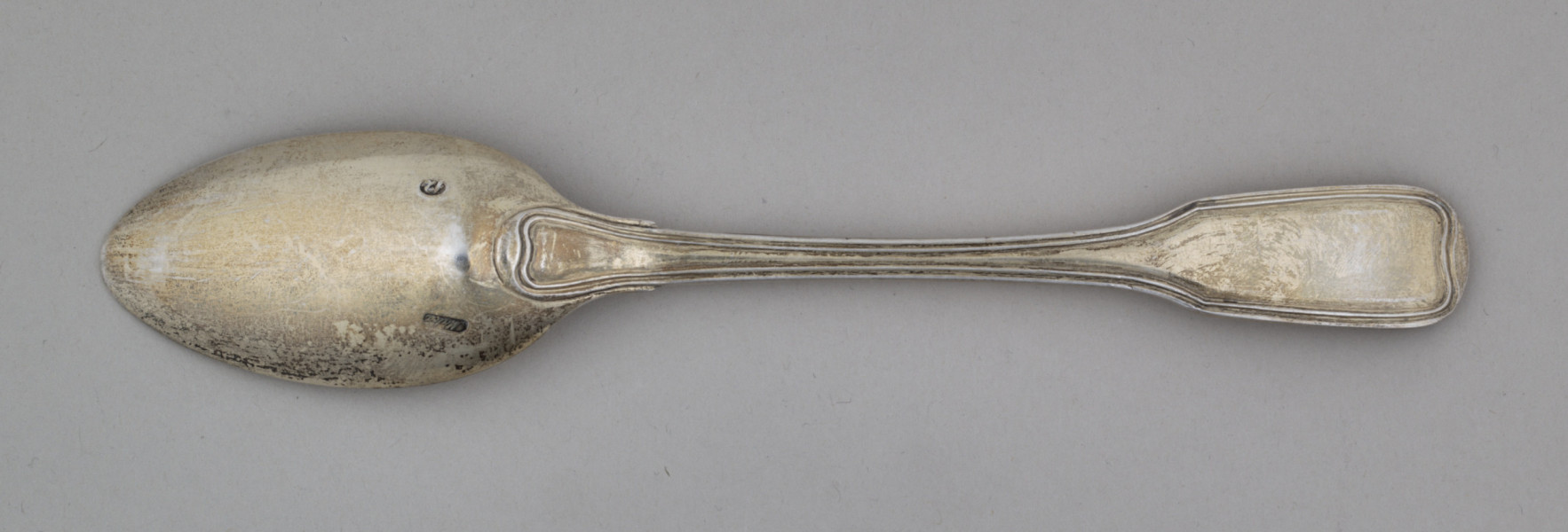 łyżka obiadowa o głębokiej owoidalnej czarce. Trzonek płaski, lekko wygięty, rozszerzający się przy zakończeniu