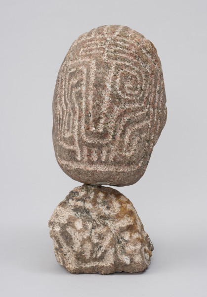 Wódz Apaczów - ujęcie z przodu; Pionowa, tektoniczna forma jajowata na postumencie z nieobrobionego polnego kamienia. Na głowie płaski stylizowany ryt, tworzący abstrakcyjny wzór łamanych lub zaokrąglonych, meandrujących linii, który sugeruje cechy twarzy ludzkiej.