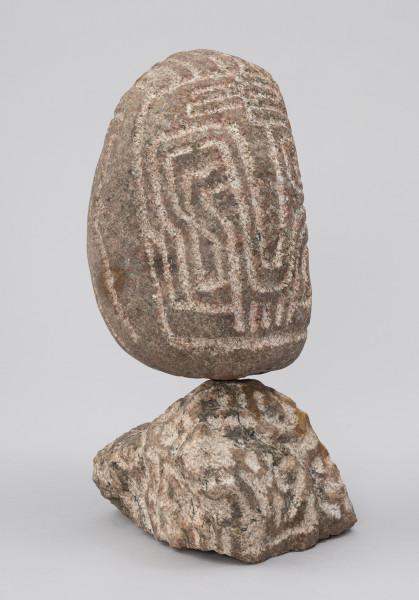 Wódz Apaczów - ujęcie przodu ze skosu z lewej; Pionowa, tektoniczna forma jajowata na postumencie z nieobrobionego polnego kamienia. Na głowie płaski stylizowany ryt, tworzący abstrakcyjny wzór łamanych lub zaokrąglonych, meandrujących linii, który od jednej strony sugeruje cechy twarzy ludzkiej.