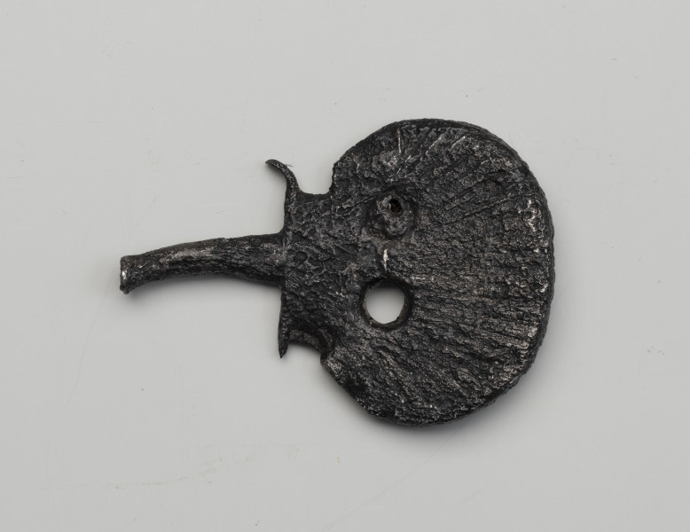 kord - detal; Tarczka w formie muszli św. Jakuba z dwoma okrągłymi otworami u dołu.