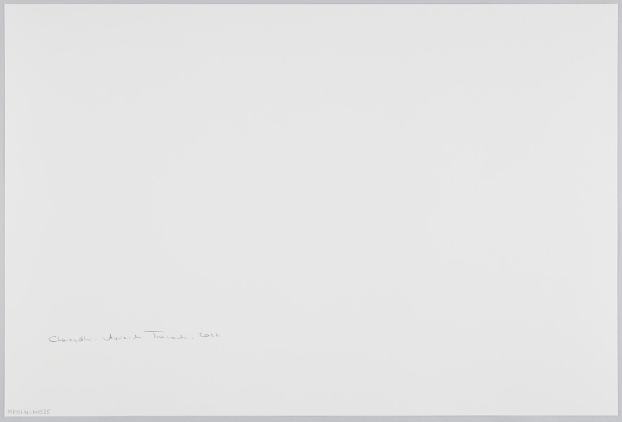 scena rodzajowa - Poziomy, barwny kadr fotograficzny przestawiający odświętnie ubraną rodzinę stojącą przy stole w domowym wnętrzu. Po lewej kobieta w granatowej sukience z ozdobna przepaską na włosach oraz 4 dzieci także w granatowych strojach. Po prawej mężczyzna w białej koszuli, czarnym, długim, połyskliwym żakiecie oraz dużej futrzanej czapie w kształcie walca. Przy krańcu stołu, gdzie stoi kobieta, znajduje się taca z dwoma srebrnymi wysokimi świecznikami, mniejszym dwuramiennym świecznikiem oraz 4 małymi świeczkami. Wszystkie świece są zapalone. Kobieta pochyla nad nimi głowę, twarz ma zasłoniętą dłońmi w geście skupienia. Mężczyzna w ręku trzyma kilka kartek papieru.