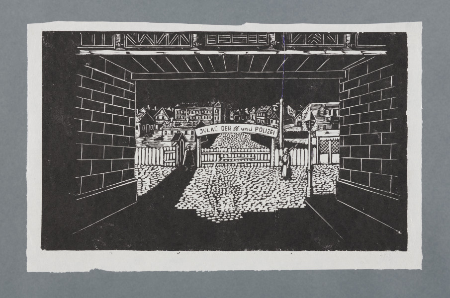 scena rodzajowa - Widok na płot i drewnianą bramę od strony wiaduktu pod przejazdem kolejowym. Na pierwszym planie po bokach murowane ściany wiaduktu, u góry widoczne żelazne balustrady. Ulica brukowana, po bokach chodniki, z prawej stoi uliczna latarnia. Na wprost płot, drewniana, niska, zamknięta brama, z lewej otwarta furtka, za nią widoczna budka strażnicza. Na bramą półokrągła tablica z napisem: Gulag der SS und Polizei. Przed bramą, z prawej strony stoi żołnierz w szynelu, z karabinem na ramieniu. W głębi, za ogrodzeniem widoczna ulica, panorama parterowych i piętrowych domów.