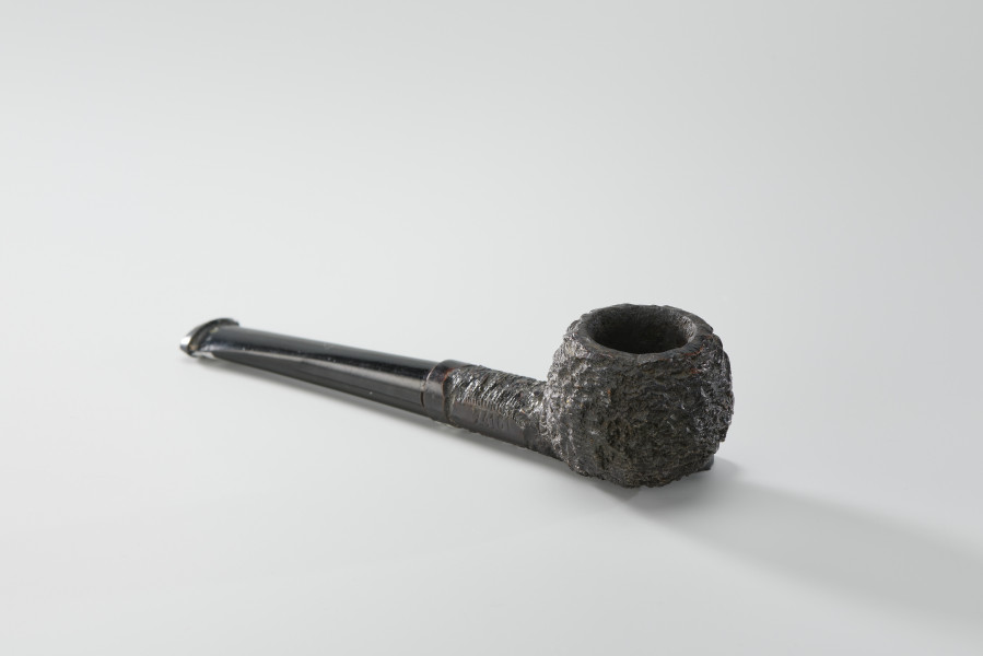 Fajka - Fajka w kolorze czarnym, z drewnianą powierzchnią główki i cybucha z wyraźnymi ciosaniami (ryflowanie). Część z ustnikiem gładka, możliwe jest jej odkręcenie.